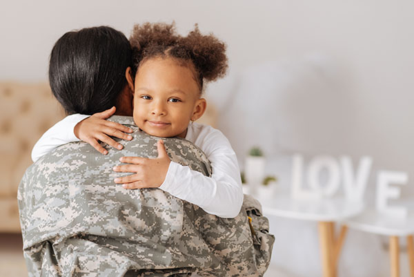 Loving mom returning home to her child Feeling her close again. Beautiful charming kind girl looking delighted and hugging her mother after not seeing her for a few months
